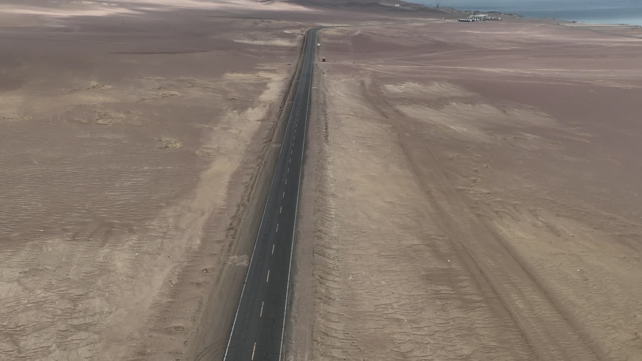 바다, ica, huacachina 근처의 긴 황량한 도로에서 자전거를 타는 사람의 공중 샷