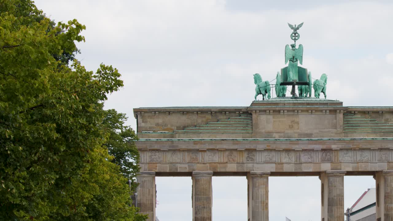 Plano medio estático de la Puerta de Brandeburgo neoclásica bajo un cielo brillante y cubierto en Berlín