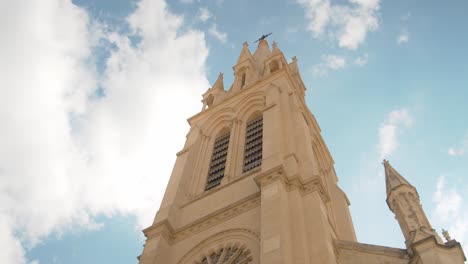 Low-angle-circling-shot-of-tower-facade-of-Sainte-Anne-church,-Montpellier