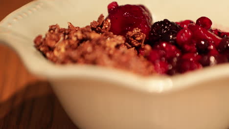 a healthy bowl of fruit berries and cereals - slow motion pan right