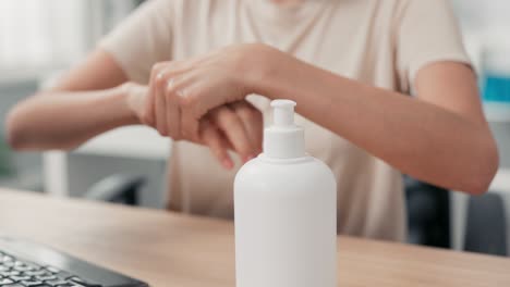 shot of a woman's hand disinfecting her hands in the office before starting to work on the computer, hygiene care, protection against bacteria, viruses, safety in the company