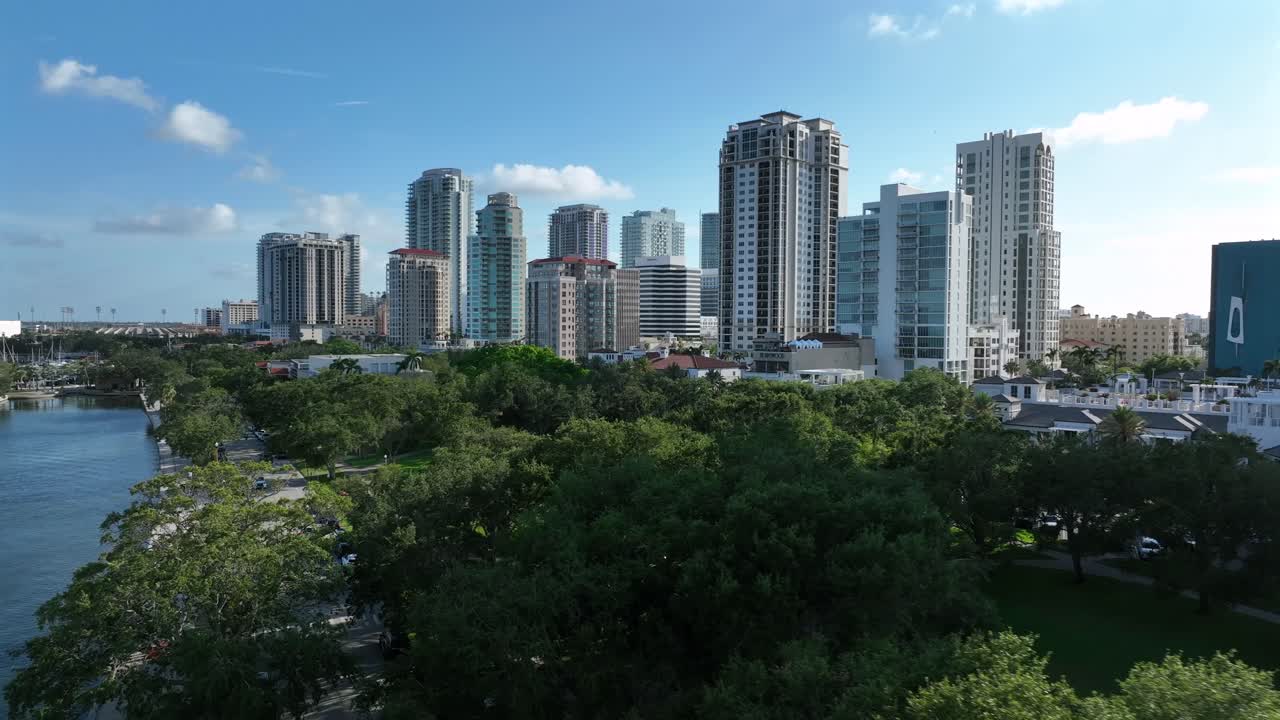 St Petersburg, FL skyline with high-rise buildings and modern architecture. Features residential and commercial spaces, plus a green park adding nature to the cityscape. Aerial view.