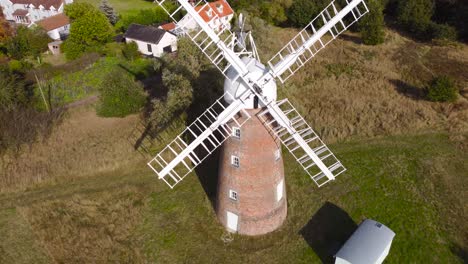 billingford windmill at a farm land area with house in diss, norfolk - aerial drone flying backward shot