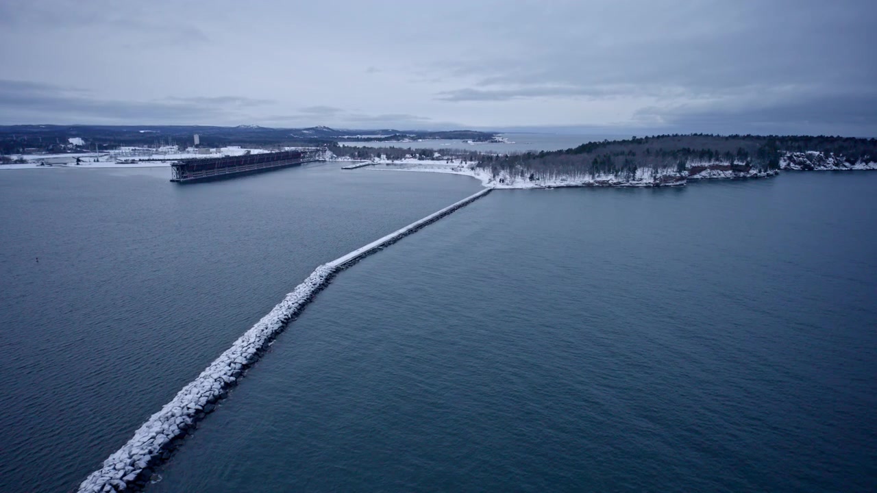 Ripresa con drone di un volo sopra un frangiflutti nel Lago Superiore, situato a Marquette, Michigan, in inverno