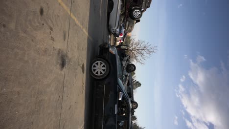 demolished and wrecked vehicles stacked on top of each other in a parking lot, vertical