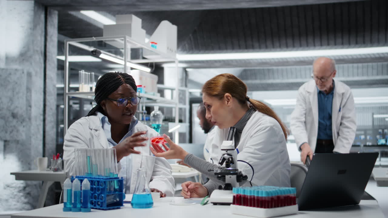 Team of laboratory researchers evaluating pharmaceutical compound in petri dish