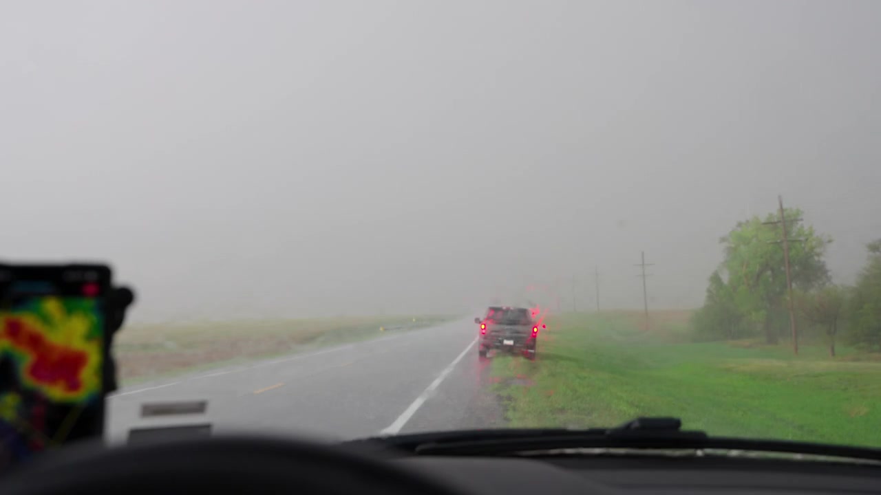 Pioggia battente e grandine cadono sul finestrino dell'auto durante un temporale.
