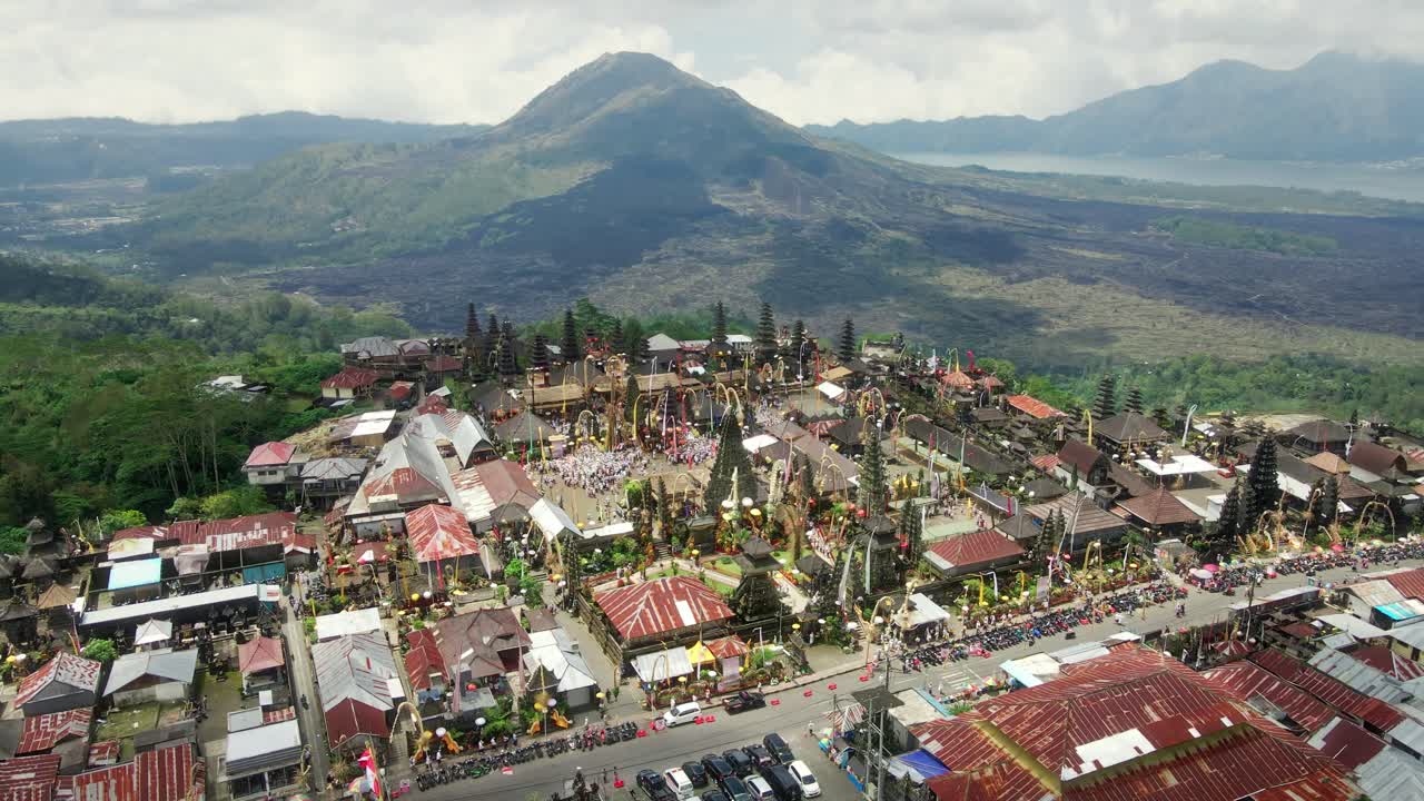 video aéreo del templo llamado pura tuluk biyu con el volcán batur en el fondo