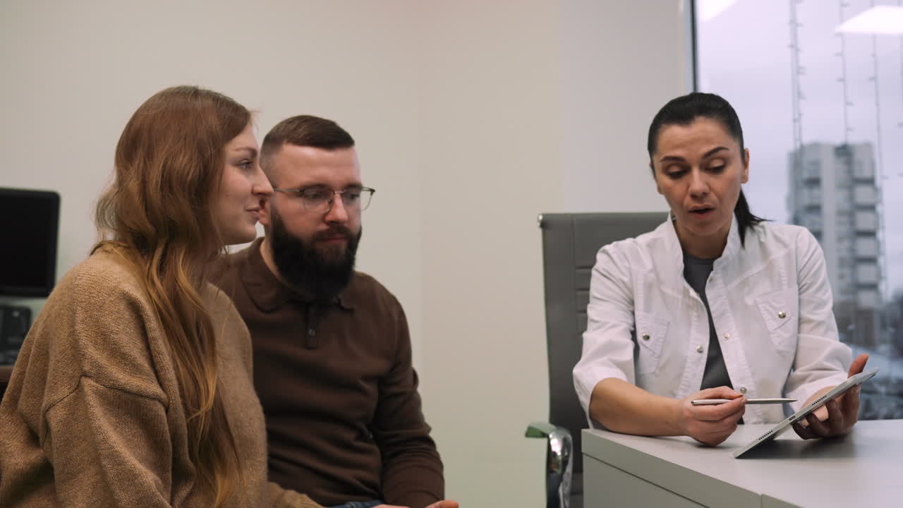 의사 는 부부 에게 기기 에 있는 이미지 를 보여 준다