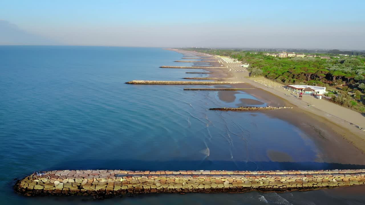 vista panorámica de las tranquilas y tranquilas aguas del mar adriático moviéndose hacia la playa de la ciudad costera de caorle, italia