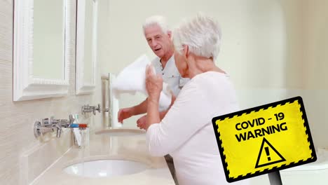 Aufmerksamkeitsschild-Mit-Covid-19-Und-Warntext-Gegen-Zwei-ältere-Frauen,-Die-Sich-Die-Hände-Waschen