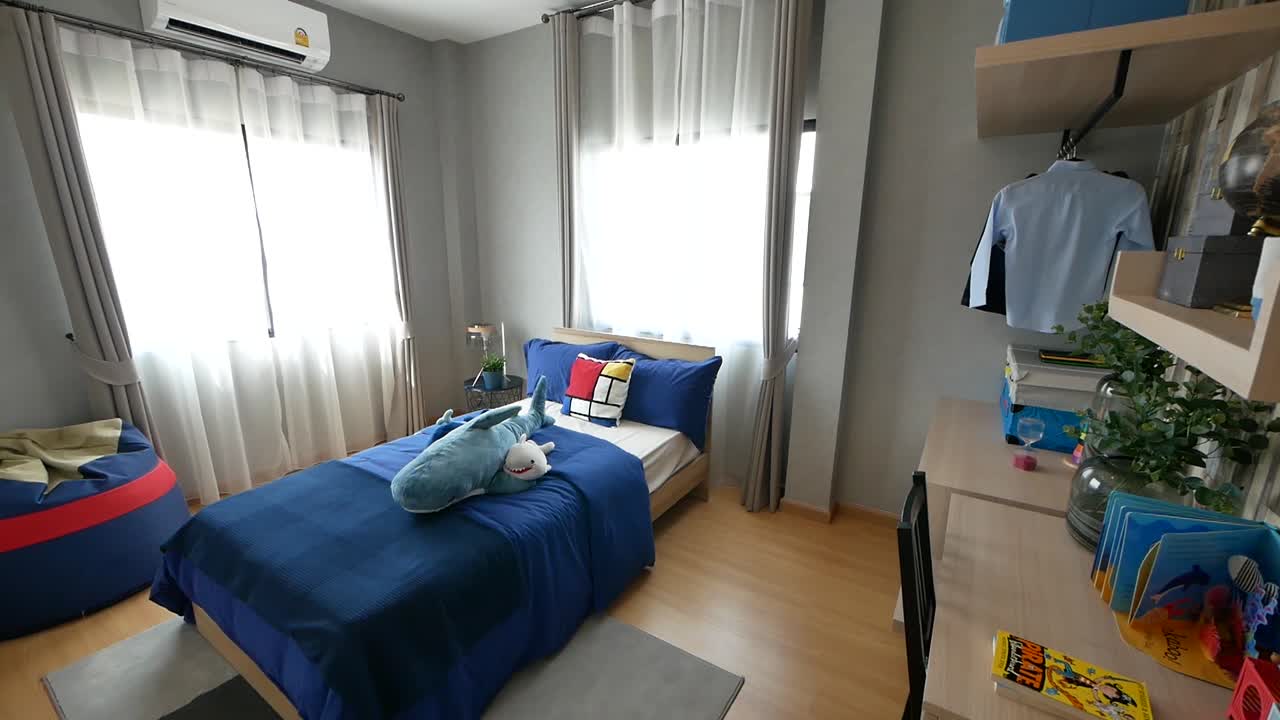 Camera da letto per bambini a tema blu, graziosa e ordinata.