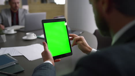 trabajador financiero navegando por la pantalla verde de la tableta buscando en la web en el centro de negocios.