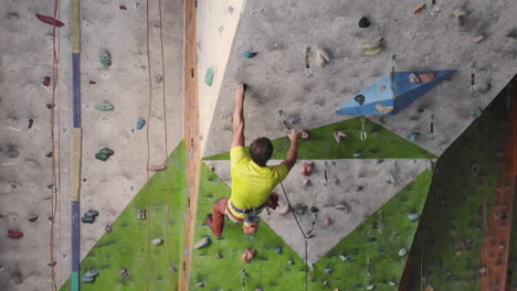 Una-Joven-Escaladora-Está-Escalando-En-El-Gimnasio-De-Escalada-Interior.-Mujer-Bonita-Y-Delgada-Haciendo-Ejercicio-En-La-Pared-Del-Gimnasio-De-Escalada-Interior