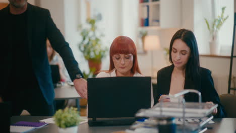 coworkers discussing at desk in office.