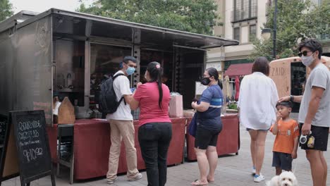 people in line waiting to buy roasted chicken. local street vendors