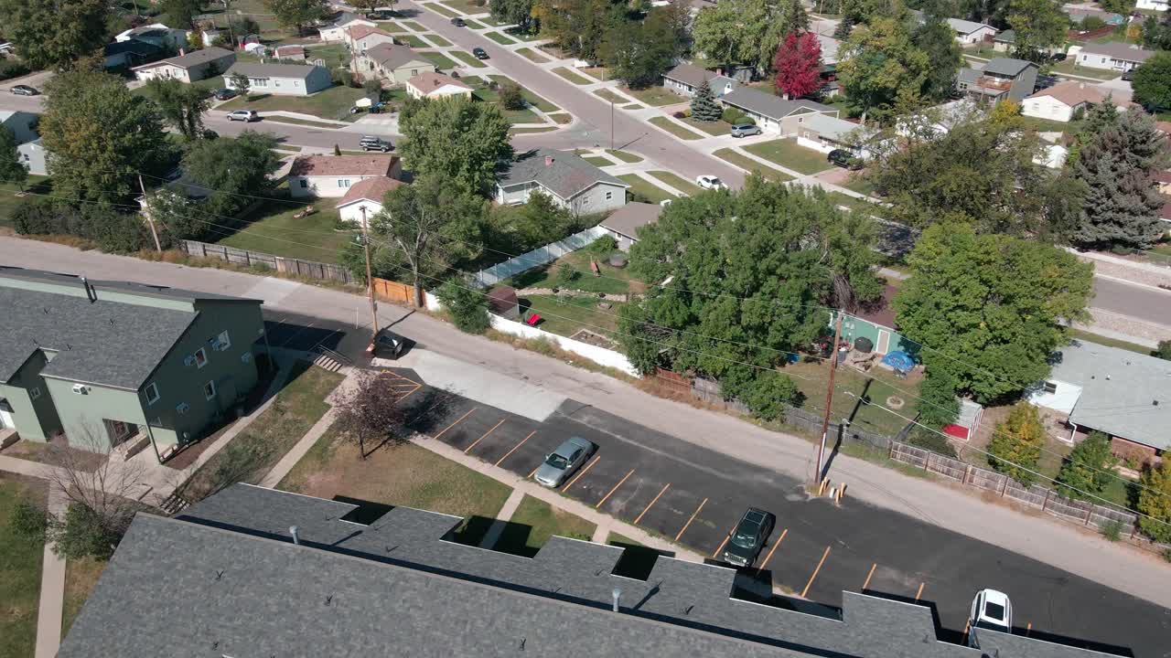 Aerial drone footage in a suburban neighborhood revealing an apartment complex