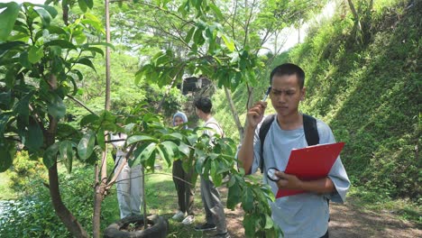 asian boy student learning and exploring nature with magnifying glass