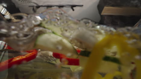 woman putting vegetables into water