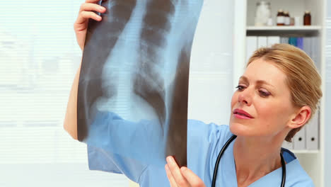 Surgeon-looking-at-xray-at-her-desk