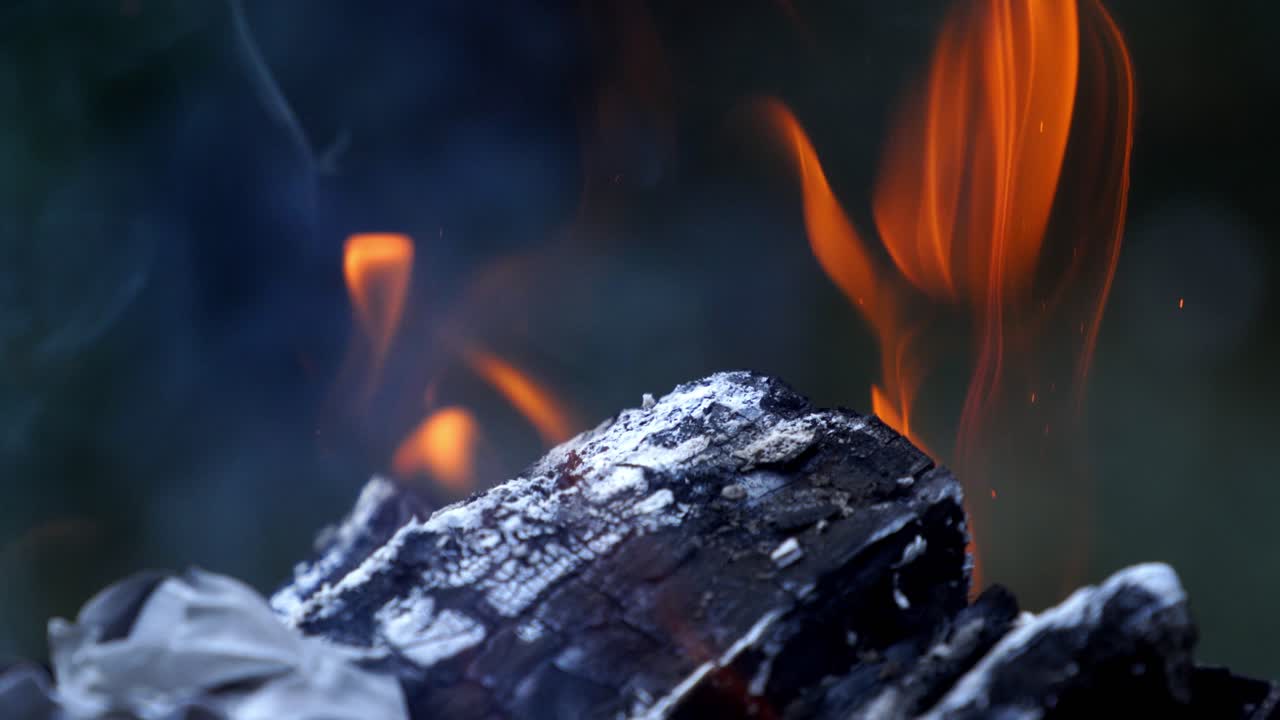 Firewood in flame close up. Fire flames of dying embers, close up