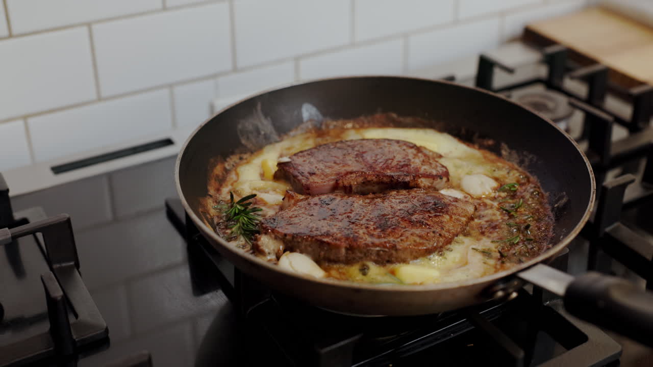 Steak cooking in pan with butter and garlic