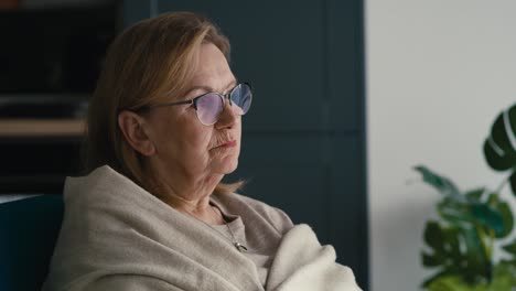 close up of thoughtful caucasian senior woman sitting in armchair and looking away