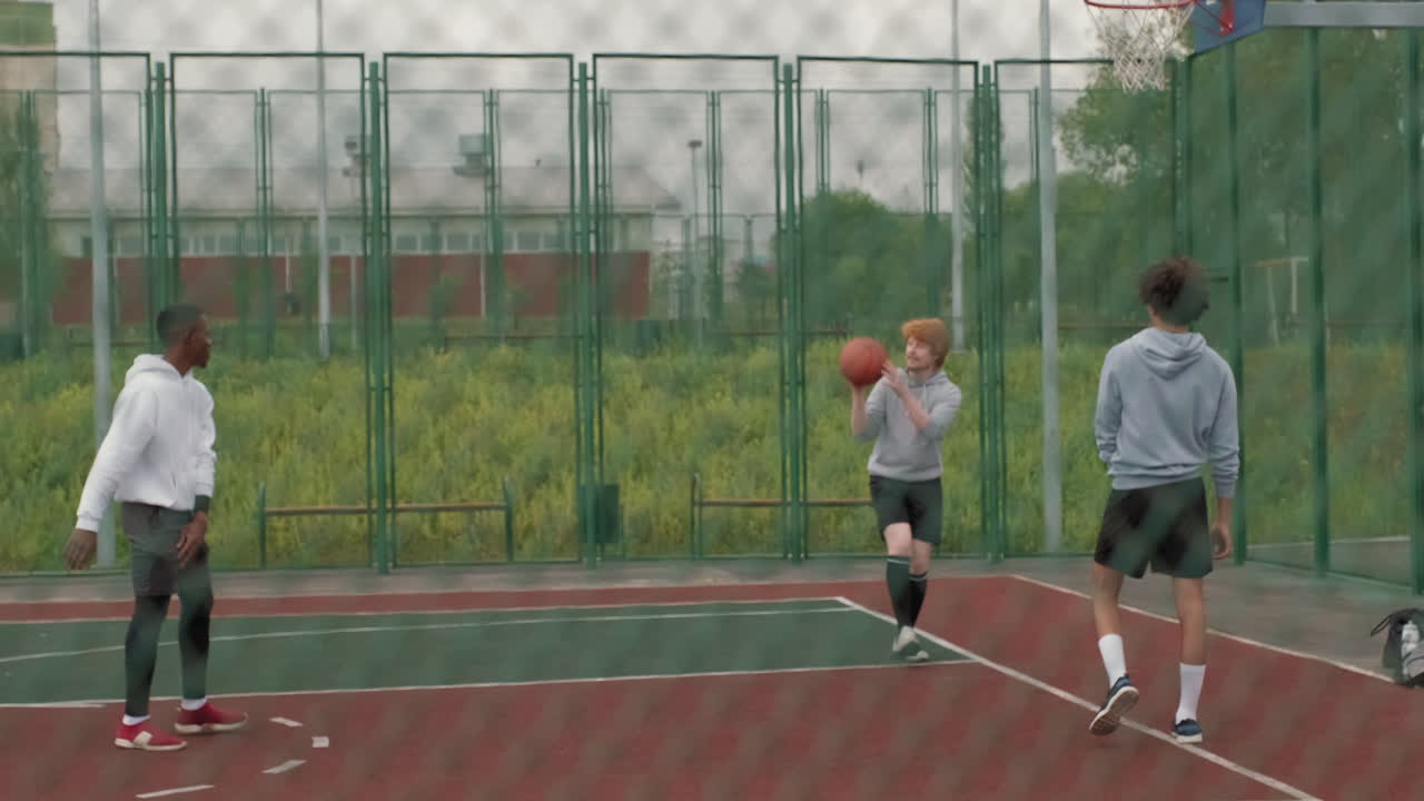 People playing basketball on an outdoor court