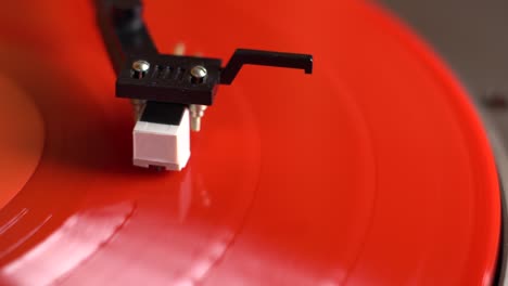 placa de vinilo roja giratoria en una mesa giratoria