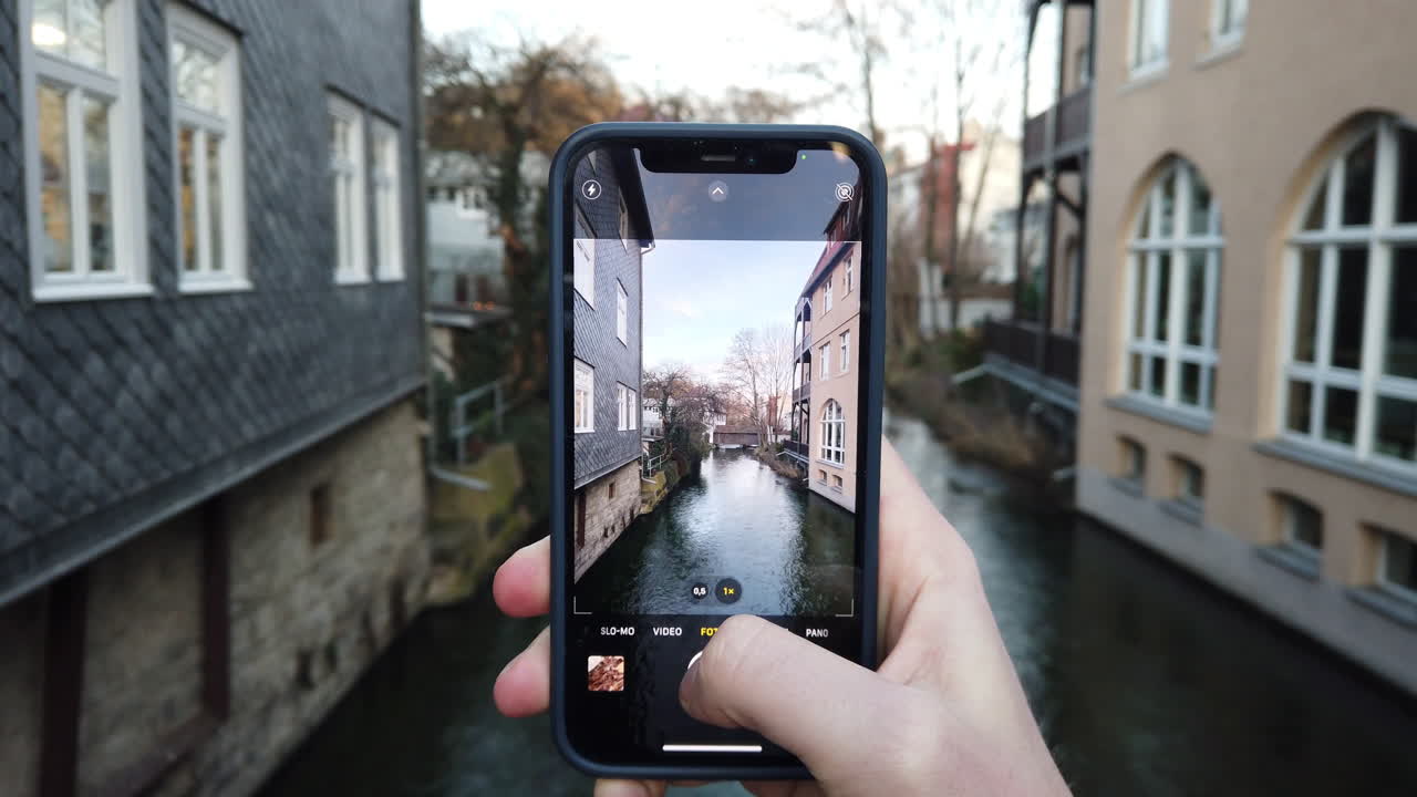 tomar fotografías con un teléfono inteligente del histórico canal en el casco antiguo de erfurt