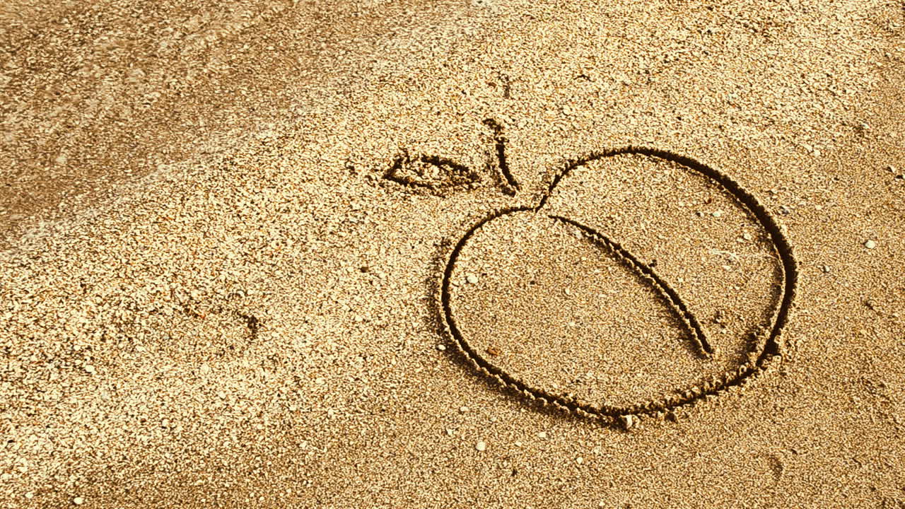 Apple drawing on sand. Drawing on sand