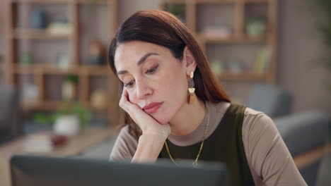 tired woman working on laptop at home