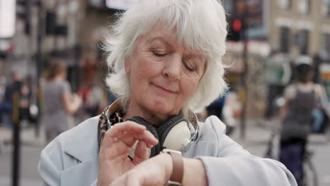 slow motion portrait of happy mature old woman using smart watch