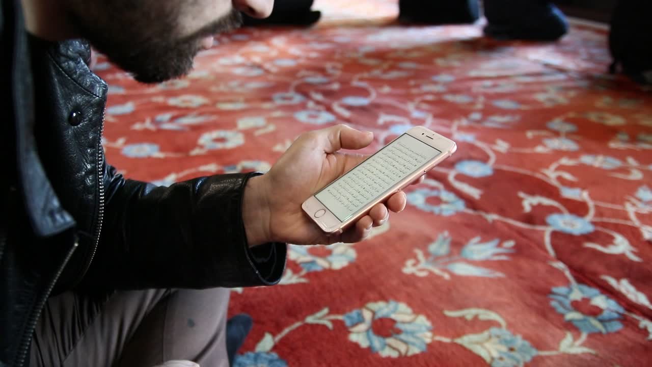 Musulmano legge il Corano dal cellulare in moschea