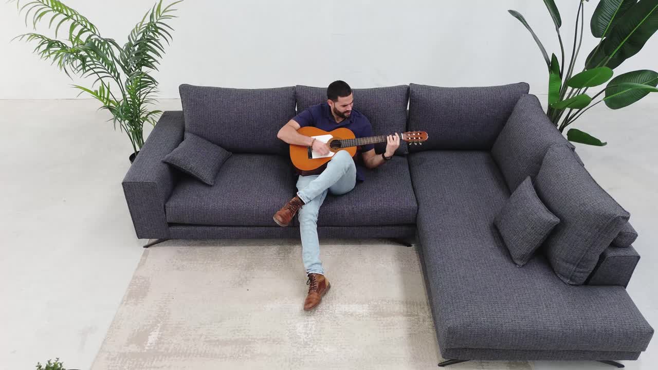 Aerial View: Man Jamming on Guitar in Cozy Living Room