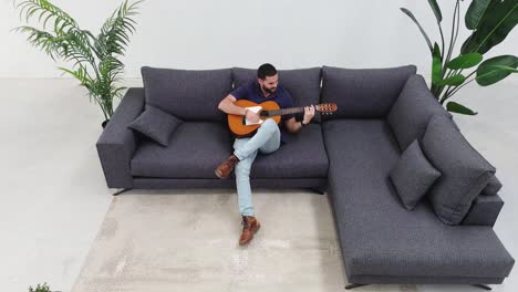 aerial view: man jamming on guitar in cozy living room