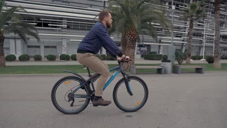 hombre montando una bicicleta en un parque de la ciudad