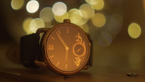 Vintage-Uhr,-Die-Auf-Einem-Holztisch-Mit-Hellen-Bokeh-Kugeln-Im-Hintergrund-Ruht,-Zeit-Verbringen-Und-Vergehen