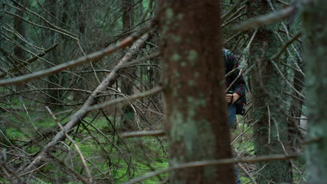 hombre con mochila caminando en el bosque verde. hombre sonriente se detiene a descansar después de la caminata