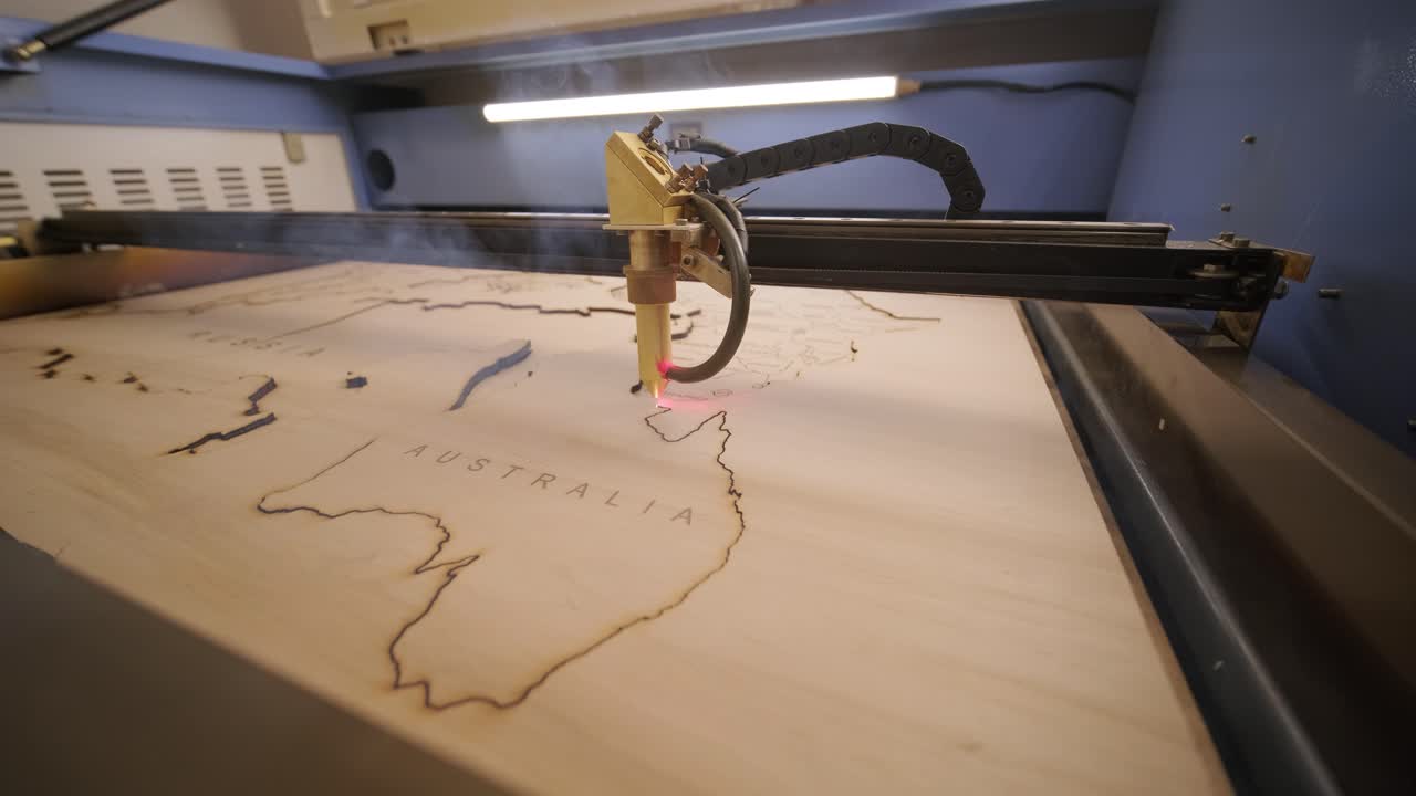 la máquina de corte por láser cnc corta el mapa del mundo en tabla de madera y contrachapado