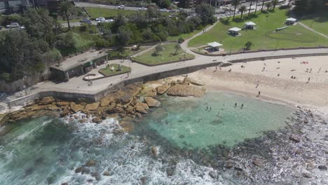 Vista-Aérea-De-Turistas-Nadando-En-La-Playa-De-Bronte-Con-Olas-Oceánicas---Vacaciones-De-Verano-En-Medio-De-La-Pandemia-De-Covid-19-En-Bronte,-Nsw,-Australia