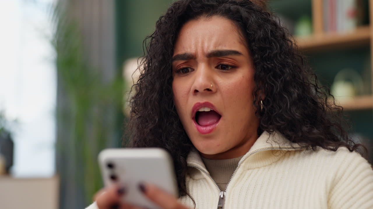 Mujer impactada al mirar el teléfono móvil