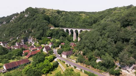 un viaducto en el campo con un tren de vapor que pasa sobre él, martel en el lote, francia