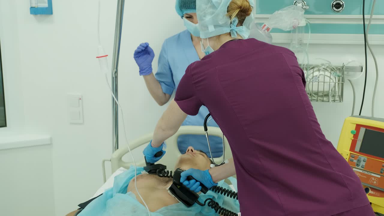 los médicos hacen reanimación a un paciente masculino en la sala de emergencias. masaje cardíaco. desfibrilación.