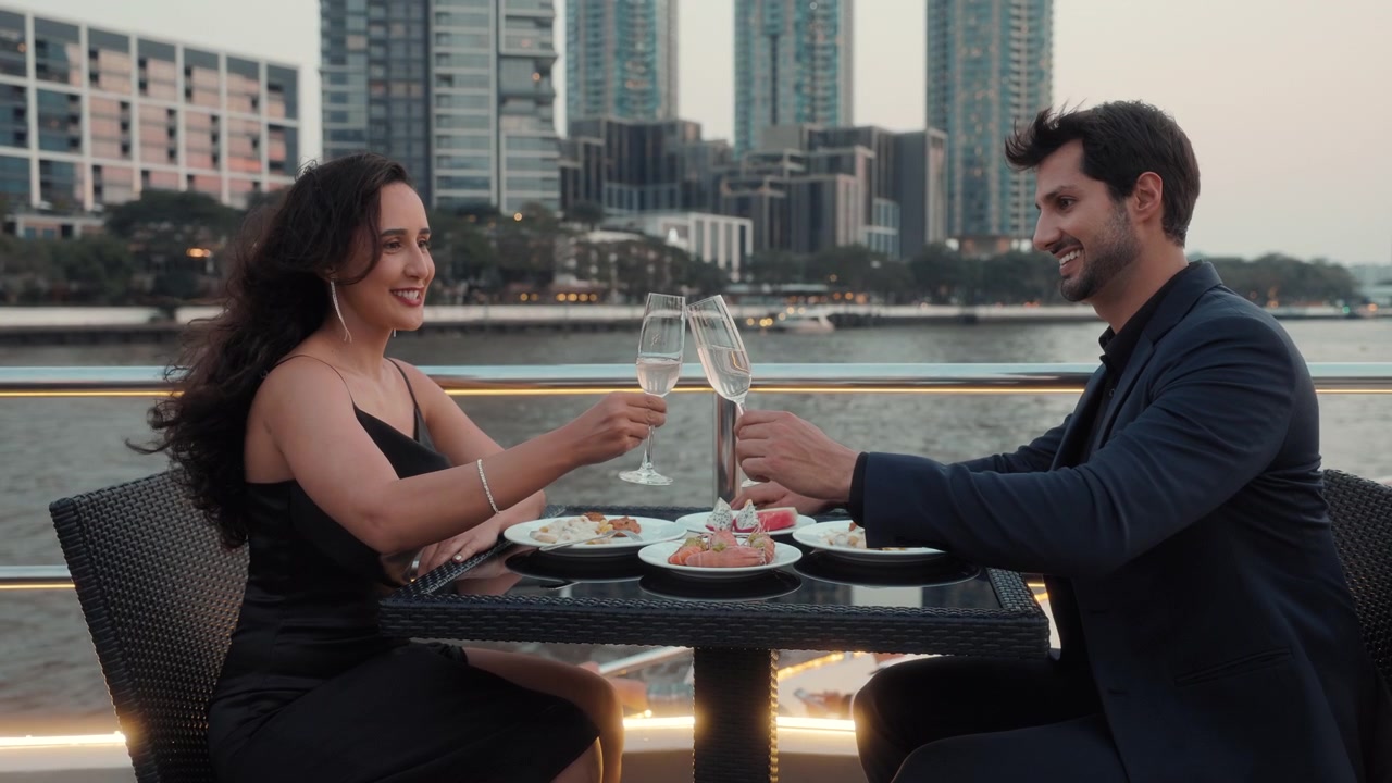 Coppia che si gode una cena romantica e brinda con champagne su uno yacht di lusso.