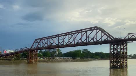 Distinctive-Truss-Suspended-Bridge-Over-Quiet-River-Under-Blue-Sky,-Sylhet,-Bangladesh