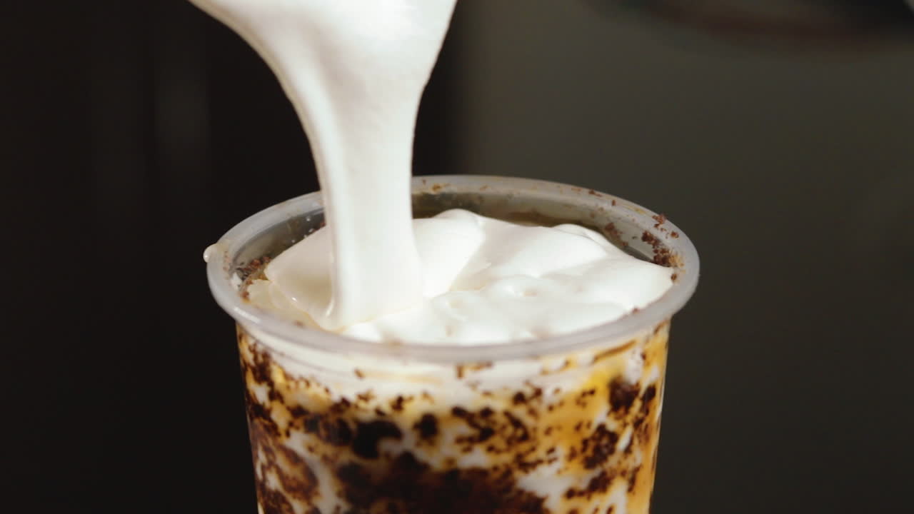 Menuangkan Krim Crème Brûlée ke dalam cangkir teh susu