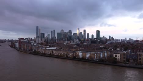 Toma-Aérea-De-Canary-Wharf-Y-El-Horizonte-De-La-Ciudad-De-Londres-Con-Nubes-Tormentosas