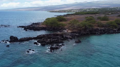 4K-cinematic-clockwise-drone-shot-of-waves-crashing-onto-lava-rock-at-Waialea-Beach-near-Kona