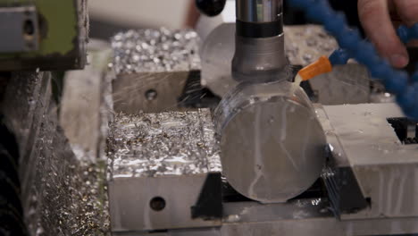 A-close-up-of-a-spinning-CNC-machine-cutting-a-wet-cilinder-of-aluminium